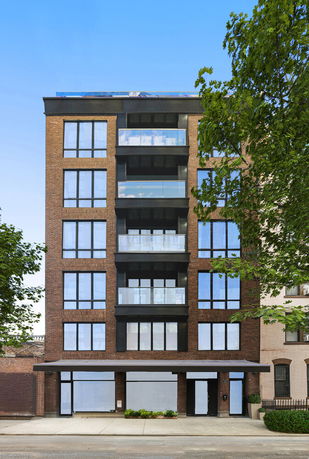 Front view of a multi-story residential building with balconies and large windows.