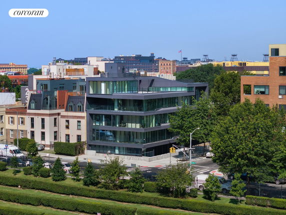 Front view of a modern multi-story building with large glass windows.