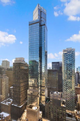 Front view of a tall, modern skyscraper with a glass facade.