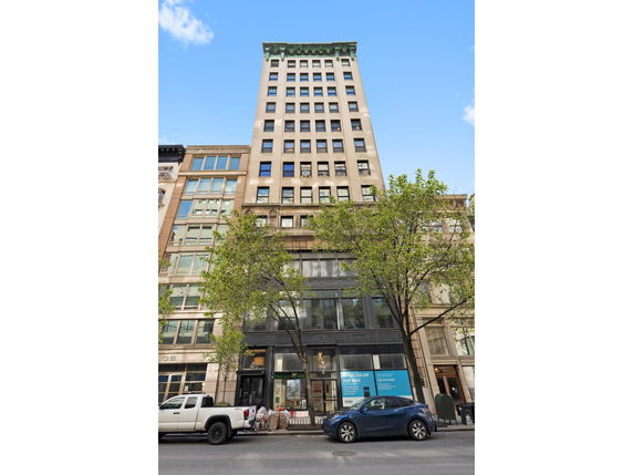 Front view of a tall, multi-story building with large windows and distinct architectural details.