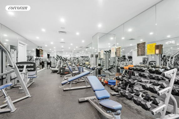 Interior view of a gym with various fitness equipment and weights.