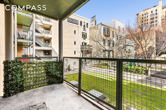 View from a balcony overlooking a courtyard with adjacent buildings.
