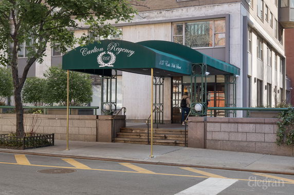 Front view of a building with a green canopy entrance.