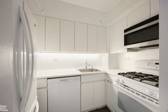 Front view of a modern, multi-story house with a pathway leading to the entrance.