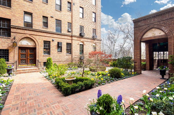 Front view of a brick building with a landscaped garden walkway.
