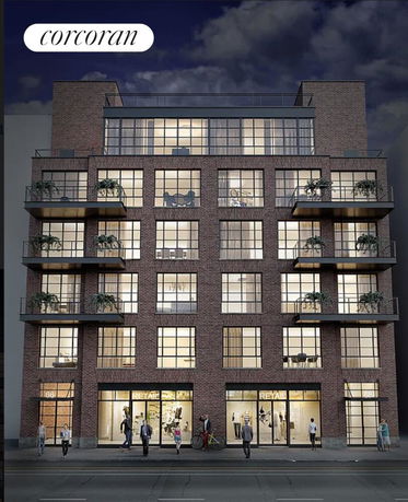 Front view of a multi-story brick building with large windows and balconies.