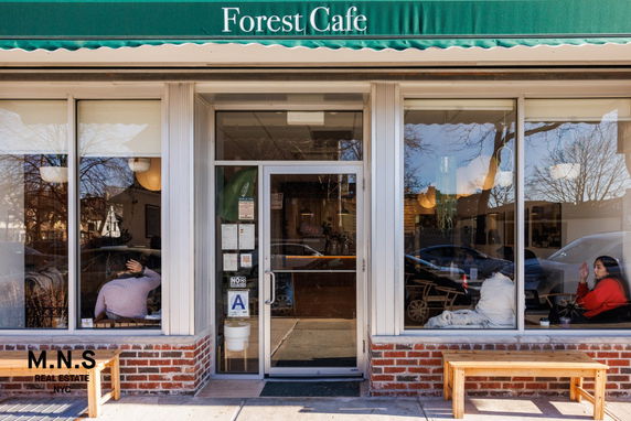 Front view of Forest Cafe with large glass windows and a green awning.