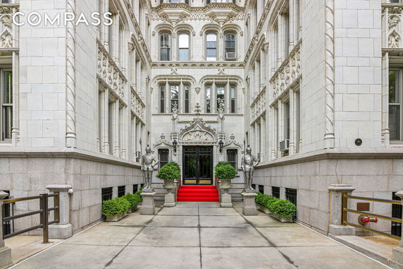Elevated view of an ornate building entryway with gothic architectural details and a red carpet at the entrance.