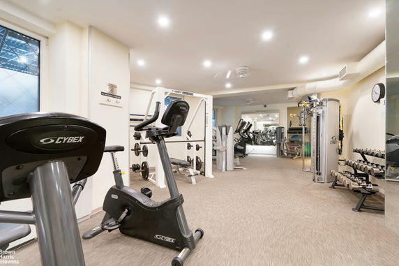 Interior view of a gym with exercise equipment and weights.