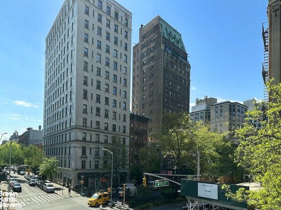 View of multiple multi-story buildings on a busy city street corner.