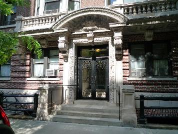 Front view of a multi-story brick building with a decorative entrance.