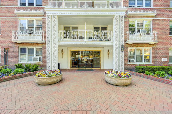 Front view of a multi-story building with decorative balcony railings and entrance.