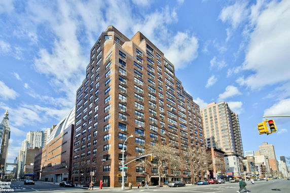 Front view of a multi-story brick building at a street corner.
