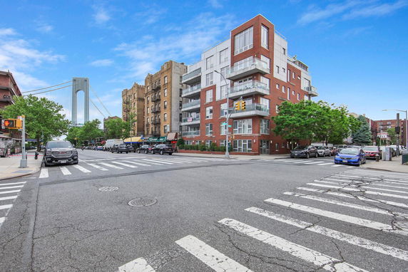 Street view showing a modern multi-story building and nearby structures.