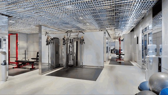 Indoor gym area with exercise machines and equipment.
