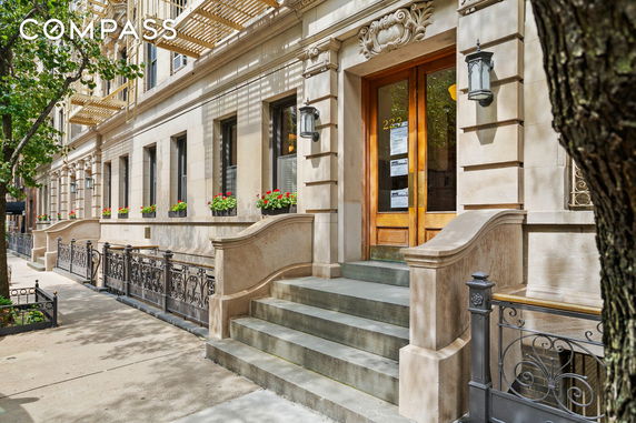 Front view of a classic stone building entrance with stairs and ornate railings.