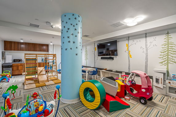 Indoor play area with toys and play equipment.