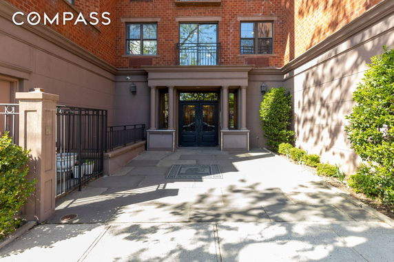 Front view of a building with a brick and stucco facade and decorative entrance.