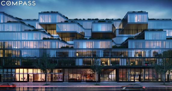 Front view of a modern multi-story building with large glass windows and terraces.