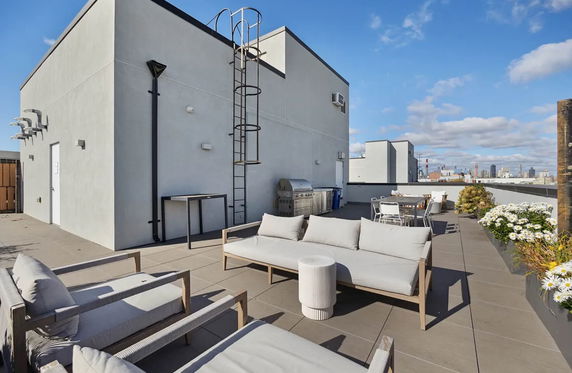 Rooftop area with outdoor seating and a barbecue grill.