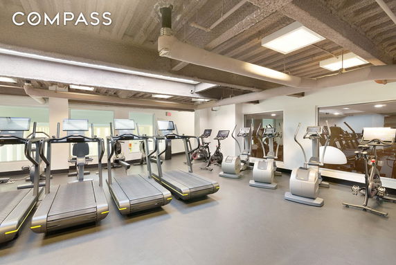 Indoor gym area with various exercise equipment including treadmills and stationary bikes.