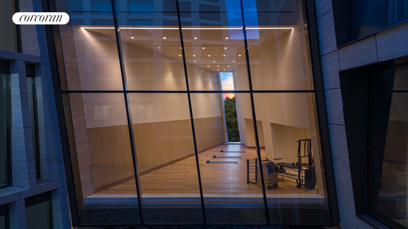 Interior view of a modern room with fitness equipment and a large glass facade.