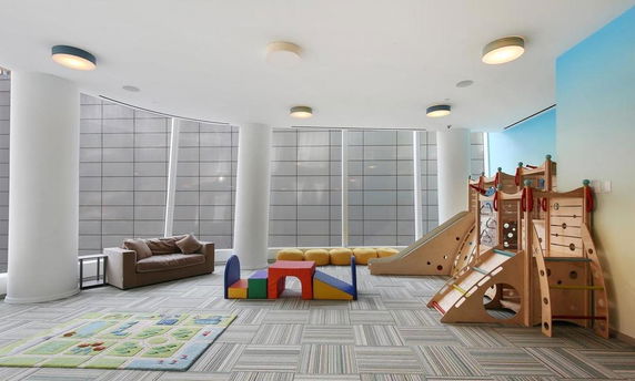 Indoor play area with modern play equipment and seating.