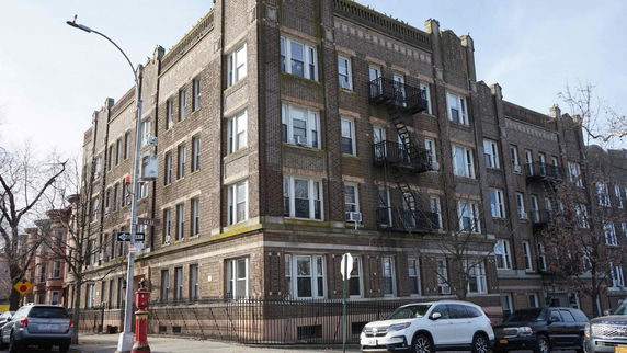Front view of a multi-story brick apartment building.