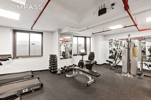 Indoor gym area with exercise equipment and mirrors