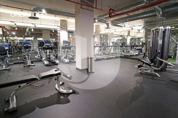 Indoor gym area with exercise machines and equipment.