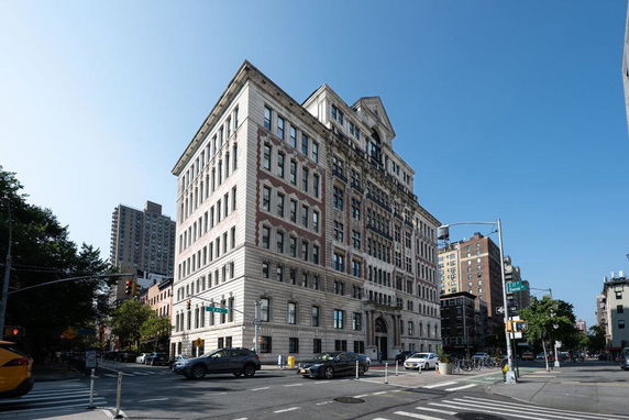 Front view of a multi-story building at a street corner.