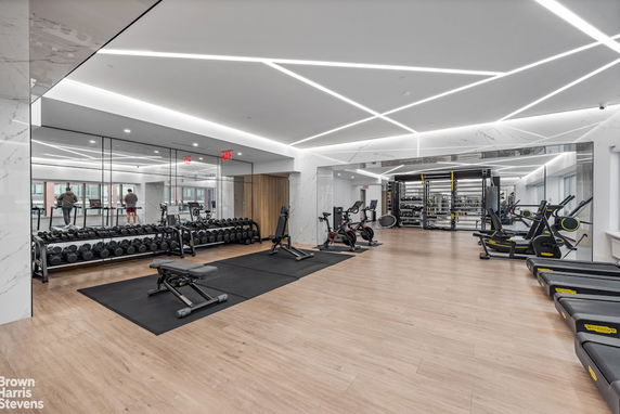 Modern indoor gym with exercise equipment and mirrored walls.