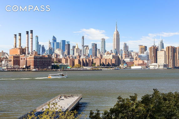 Panoramic view of a city skyline with a river and a dock in the foreground.