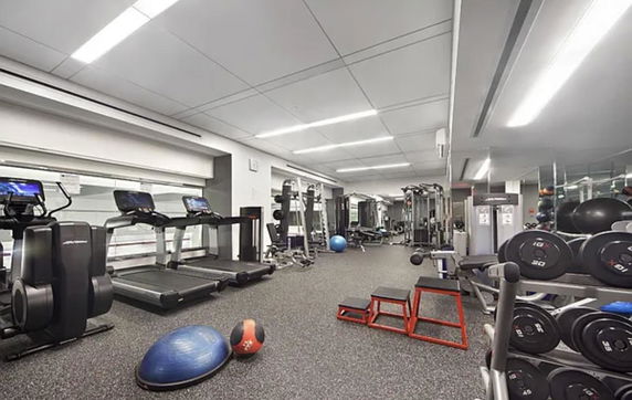 Interior of a gym with treadmills, weights, and exercise equipment.
