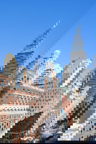 Cityscape with multiple high-rise buildings under a clear blue sky.