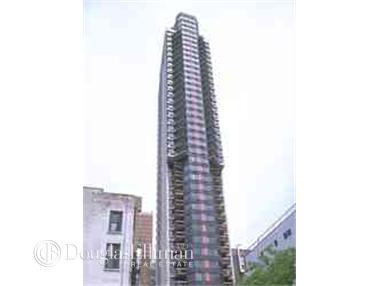 Front view of a tall residential building with multiple balconies.