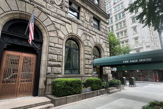 Front view of a building with arched windows and a green canopy.