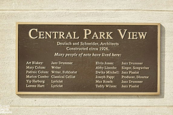 Plaque on a building exterior with names of notable residents and construction details.