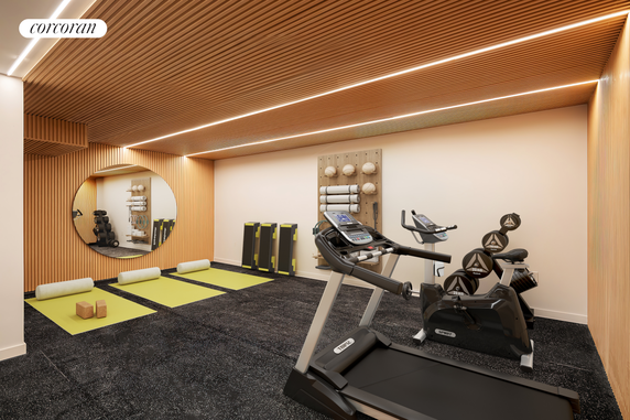 Interior view of a modern home gym with exercise equipment, wooden ceiling slats, and rubber flooring.