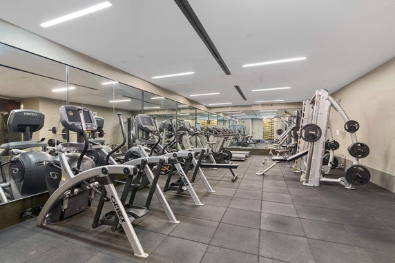 Indoor gym area with exercise equipment and mirrors.