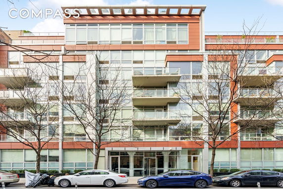 Front view of a modern multi-story apartment building with large windows and balconies.