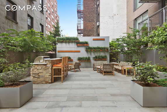 Rooftop area with seating, potted plants, and a small bar counter.