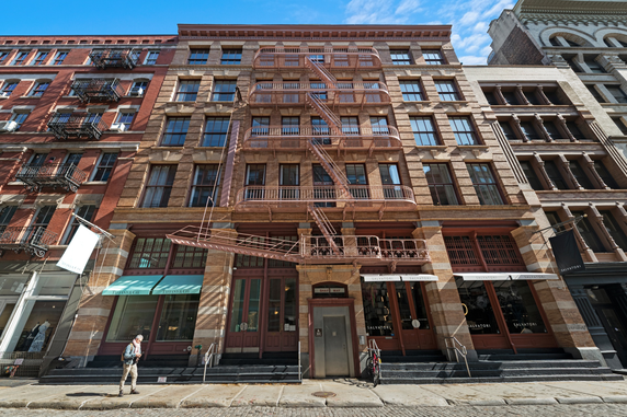 Front view of a multi-story building with fire escapes.
