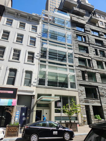 Front view of a modern multi-story building with glass facade.