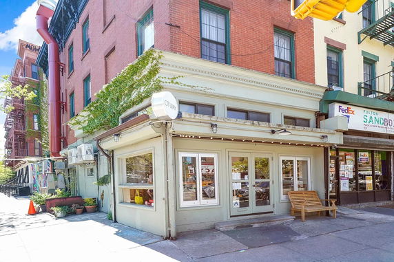 Front view of a corner building with storefronts and a brick facade.