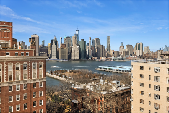 Panoramic view of a city skyline with several tall buildings and a river.