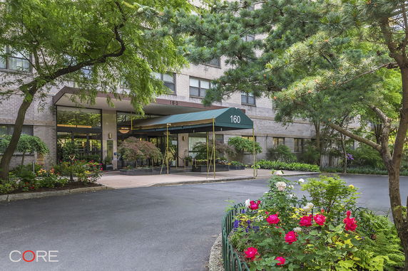 Front view of a building with an entrance canopy and surrounding greenery.