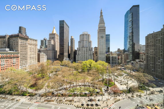 Panoramic view of cityscape with multiple skyscrapers and a park in the foreground.