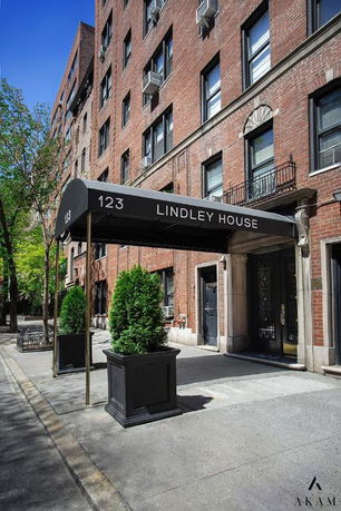Front view of a multi-story brick building with a black awning labeled 'Lindley House.'