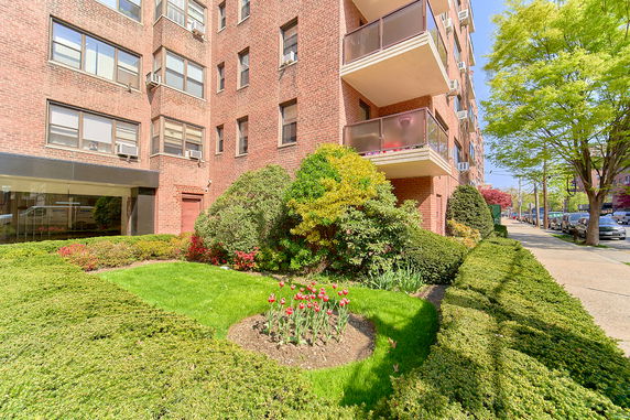 Front view of a multi-story brick apartment building with balconies.
